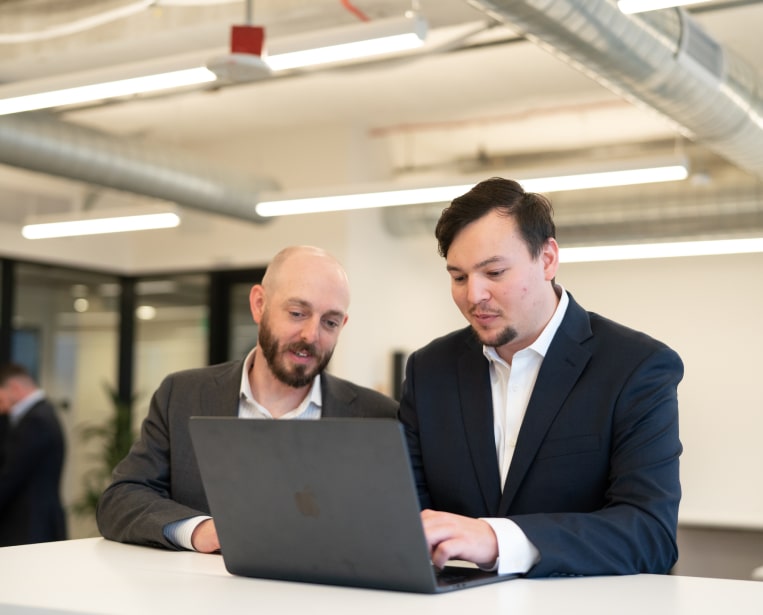 Two working professionals at a laptop